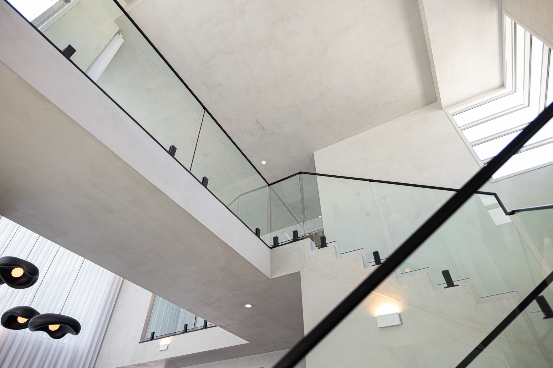 Completed double-height microcement stair volume
