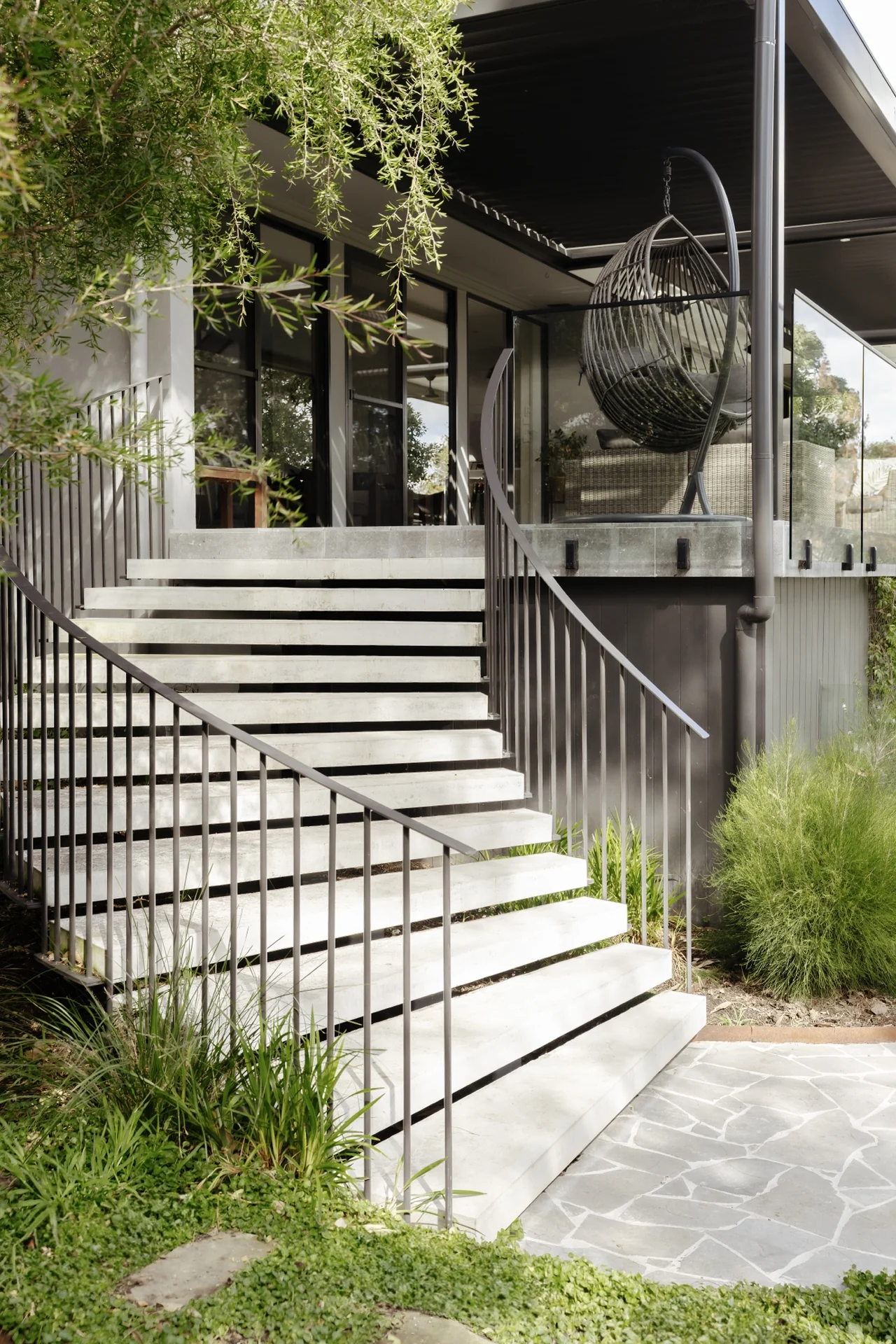 Completed floating concrete stair flight within a landscaped architectural setting