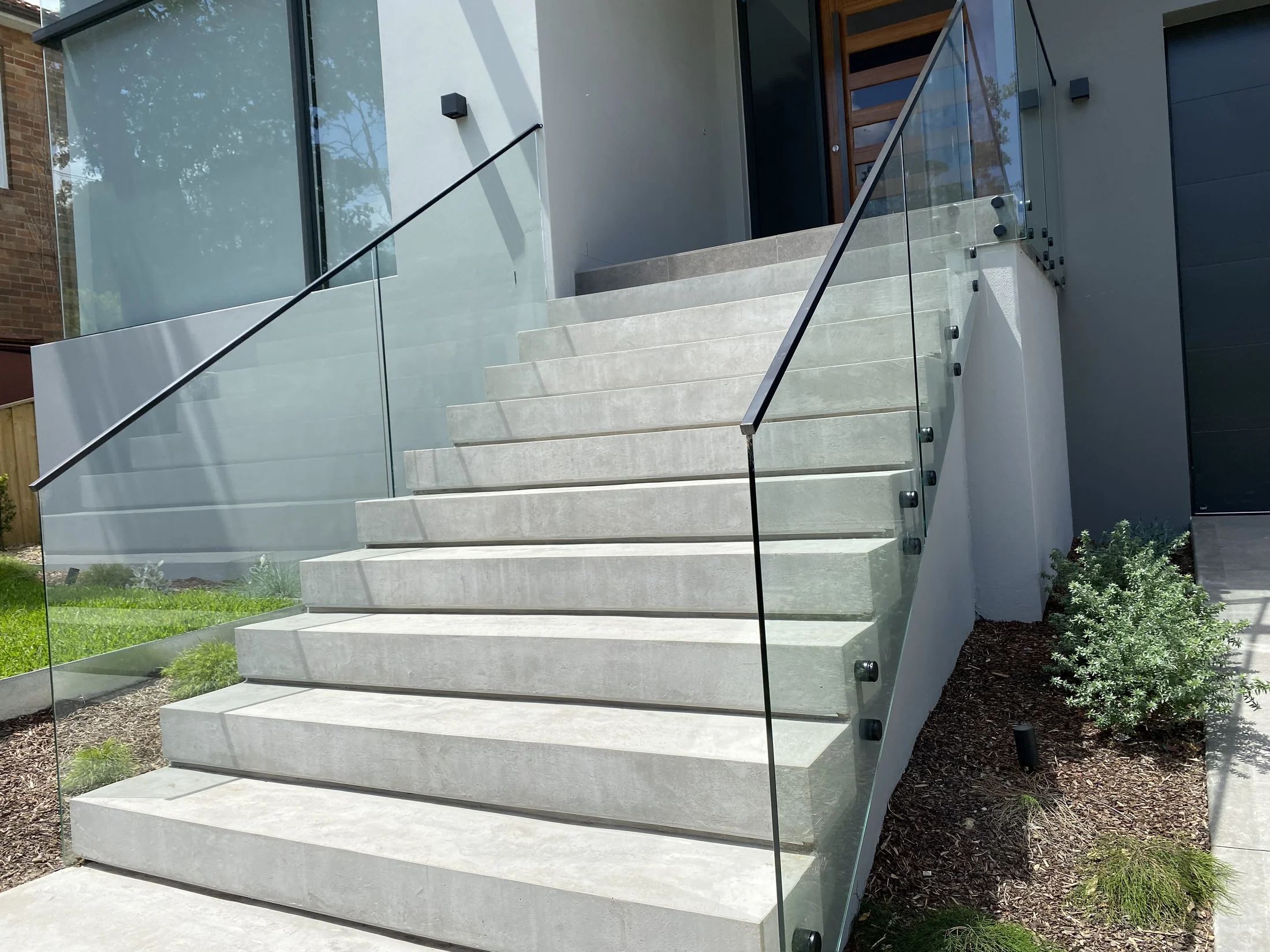 Completed architectural concrete stair transition with precise glass-lined edges
